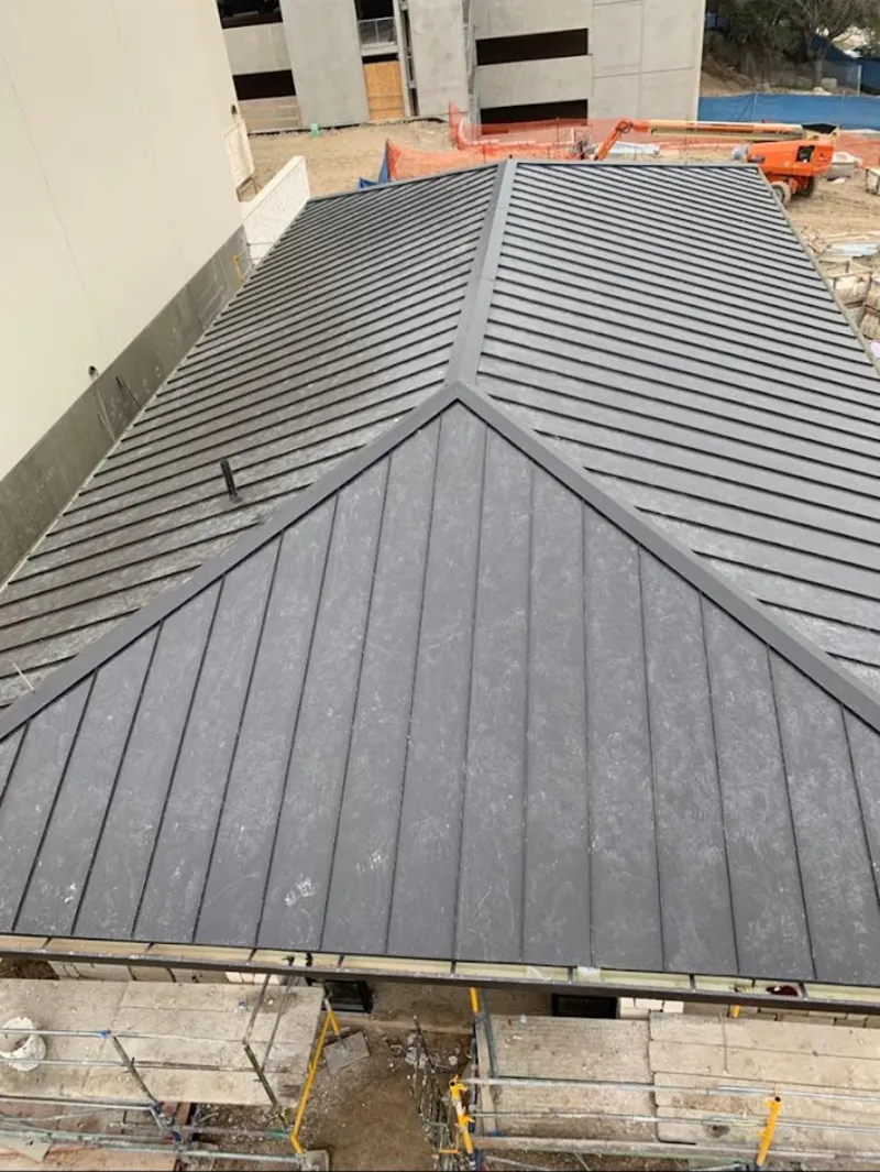 Commercial metal roof construction with crane equipment in Larkspur